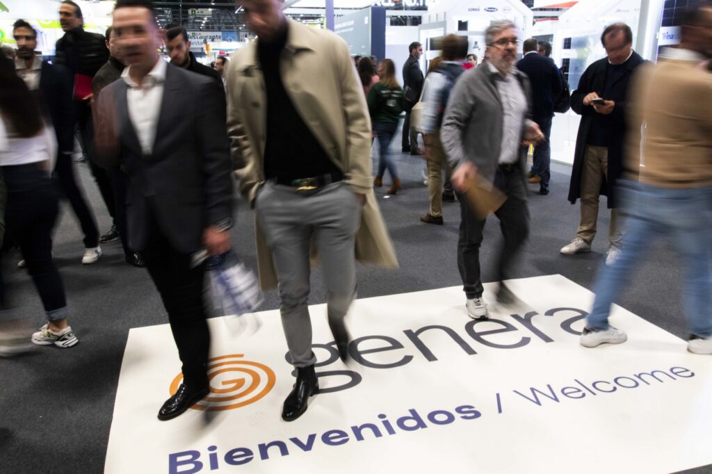 Asistentes recorren la entrada de una feria energética