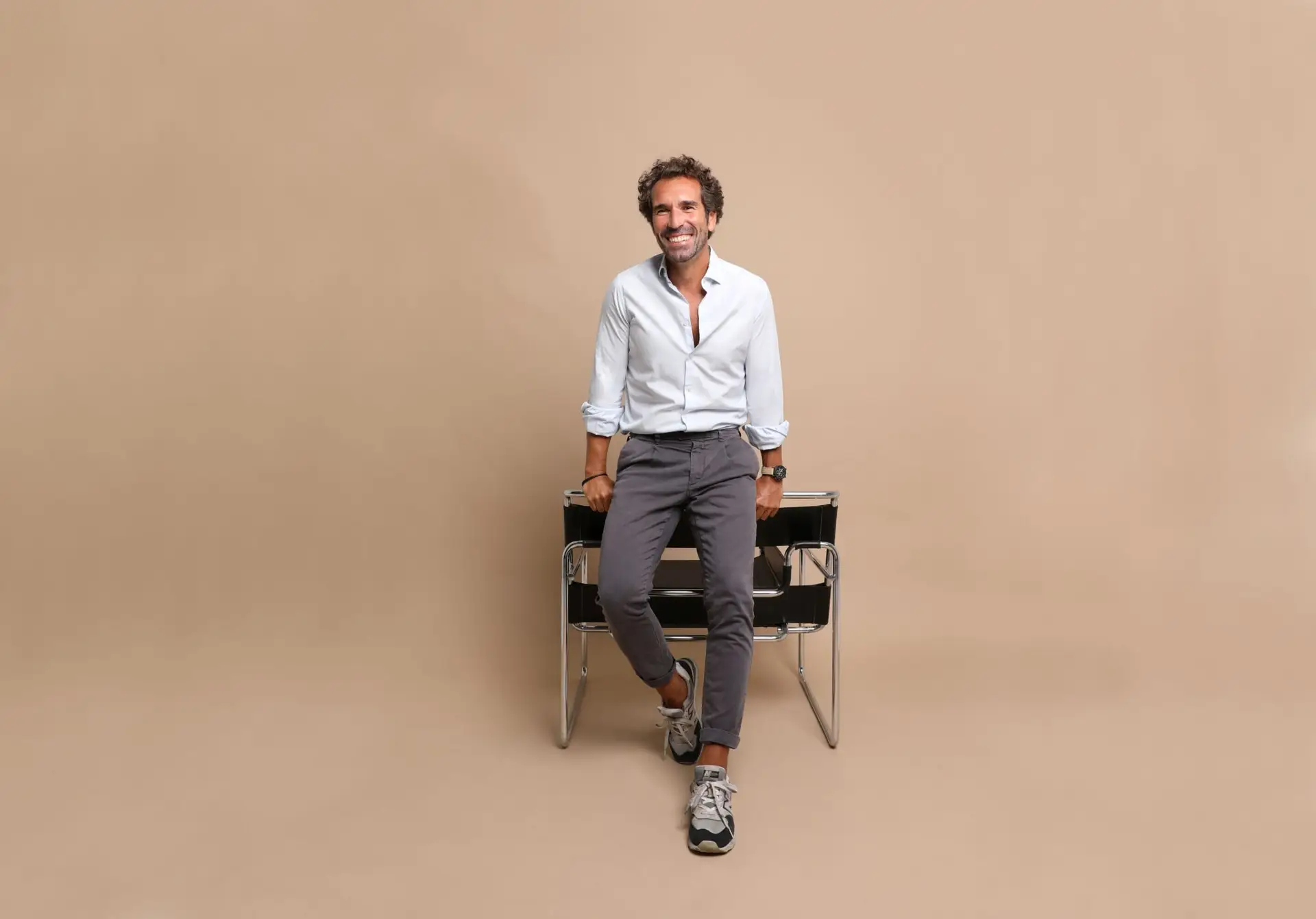Hombre sonriente sentado en una silla negra