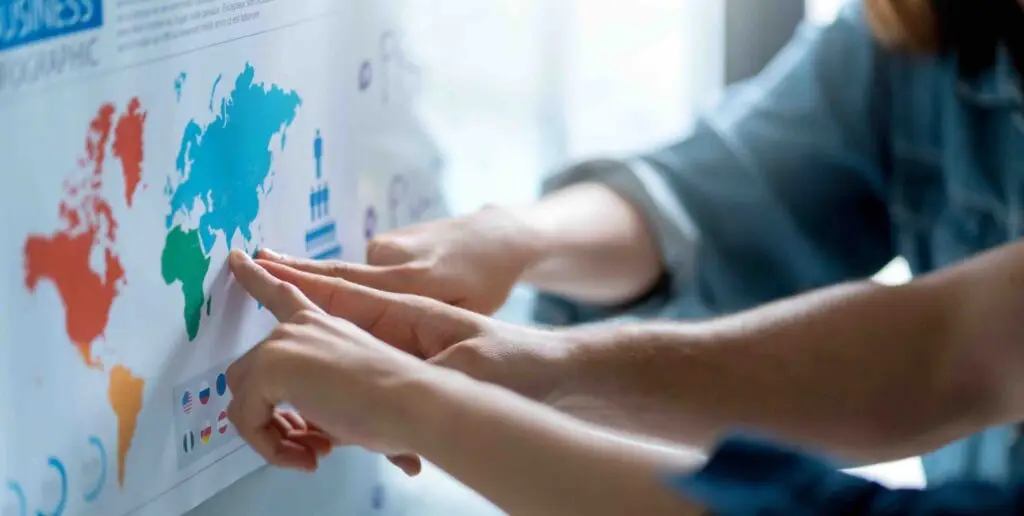 Manos señalando un mapa del mundo durante la planificación de la internacionalización de una empresa