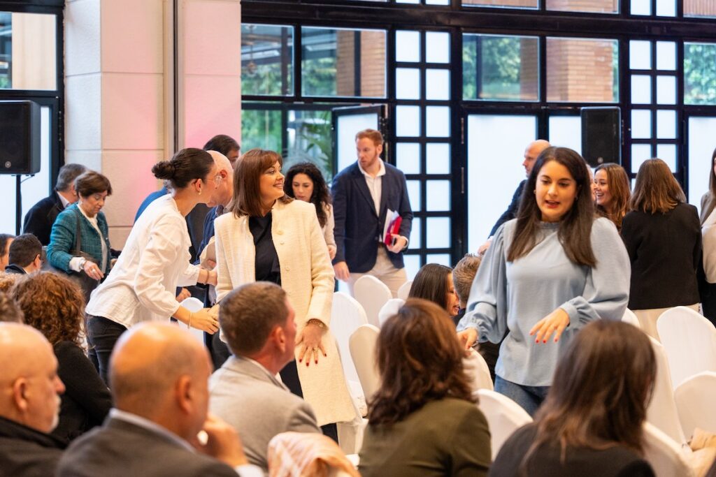 Asistentes conversan antes de un evento en una sala